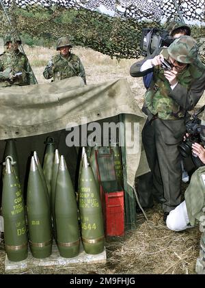 Des membres des médias japonais photographient les M107 155mm projectiles explosifs de haut niveau, tandis que les Marines des États-Unis du 3rd Bataillon, 12th Marine Regiment, 3D Marine Division, se préparent à tirer le feu de l'Howitzer tracté moyen M198 155mm à la position 10 du canon, East Camp Fuji, Japon. La zone d'entraînement fait partie de la séance de déplacement de neuf jours de tir de l'unité, conçue pour améliorer les compétences de spécialité militaire dans le domaine de l'artillerie. Sujet opération/série: FOAL EAGLE 2000 base: Base du corps marin, Camp Fuji État: Honshu pays: Japon (JPN) Banque D'Images