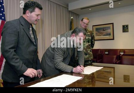 Le Dr Johnluigi Rellini (Centre), maire d'Aviano (Italie), signe un contrat d'usine d'eau entre la ville d'Aviano et la base aérienne d'Aviano sous la forme de Joseph Riccomini (à gauche), 31st Escadron contractant, et le colonel Michael Dredla, commandant du groupe de soutien 31st, look on. L'accord sur les usines est un effort conjoint entre les États-Unis et l'Italie, qui coûtera $2,3 millions à compléter et aura une capacité totale de 4,7 millions de litres par jour. Base: Aviano Air base État: Pordenone pays: Italie (ITA) Banque D'Images