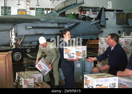 Navire Serviceman: CHEF DE LA MARINE AMÉRICAINE (guerre de surface/guerre aérienne) Rick Anderson, technicien d'électricien de l'aviation américaine de troisième classe Alyson Wolffert, et technicien de l'électronique de la marine américaine de troisième classe Matthew Brayshaw déchargent des boîtes de céréales à bord de l'USS HARY S. TRUMAN (CVN 75) pendant un réapprovisionnement connecté (CONREP). Truman est à la station dans le golfe Persique pour appuyer l'opération SOUTHERN WATCH. Objet opération/série : BASE DE VEILLE DU SUD : USS Harry S. Truman (CVN 75) Banque D'Images