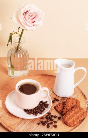 Tasse à café, petits gâteaux et pot avec lait sur un plateau en bois Concept petit déjeuner. Banque D'Images