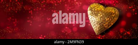 Coeur d'or sur fond rouge avec bulles de bokeh et paillettes dans un grand format panoramique, symbole d'amour, Valentin ou concept de fête des mères, espace de copie, Banque D'Images