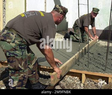 LE premier lieutenant Brian Briggs du corps DES Marines DES ÉTATS-UNIS et le sergent Shane Scovill du Bataillon de soutien des ingénieurs 8th, 2nd appui aux services de la flotte, Charlie Company, travaillent ensemble pour niveler du ciment fraîchement versé au centre communautaire de Babonneau, à Sainte-Lucie. Environ 100 Marines, soldats et aviateurs des États-Unis ont été déployés à Sainte-Lucie dans le cadre de l'opération NOUVEAUX HORIZONS. L'opération a une mission à deux volets de formation à l'état de préparation et d'assistance humanitaire dans les Caraïbes et en Amérique latine. Objet opération/série: NOUVEAUX HORIZONS base: Babonneau pays: Sainte-Lucie Banque D'Images