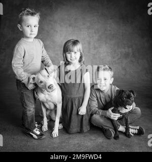 Portrait en studio de frères et sœurs avec Pug Bulldog Mix et Lab Hound Mix Banque D'Images