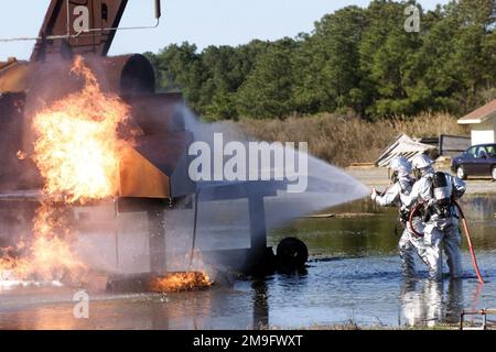 LE sergent d'ÉTAT-MAJOR de LA Force AÉRIENNE AMÉRICAINE Ronald Ackerson (à droite) et L'AVIATEUR Jason Reese, les deux pompiers de l'escadron DE génie civil 1st, Langley AFB (Virginie), éteignent les cadres d'un tir de maquette d'avion, à l'intérieur de la « Pit d'incendie », lors d'un scénario d'incendie d'avion pour l'inspection de préparation opérationnelle (ORI) DE l'escadre de COMBAT 1st. Base: Langley Air Force base État: Virginia (va) pays: Etats-Unis d'Amérique (USA) Banque D'Images