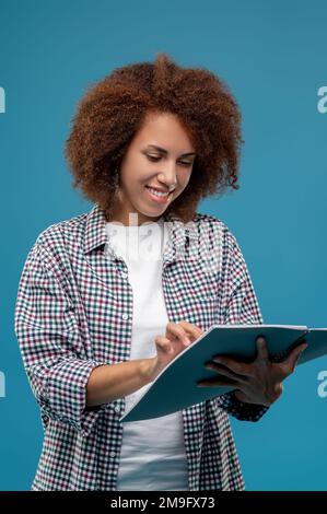 Jeune mangaer avec projet pavres dans les mains ayant l'air content Banque D'Images