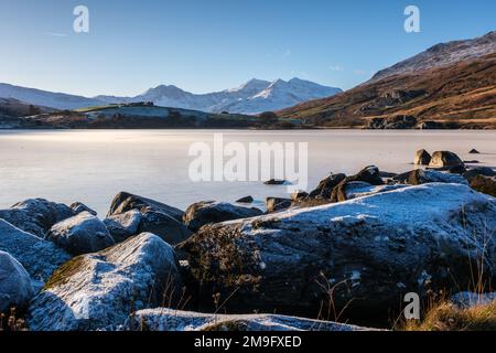 Vue sur les montagnes Snowdon Horseshoe avec un lac gelé en premier plan dans le parc national de Snowdonia, au nord du pays de Galles Banque D'Images