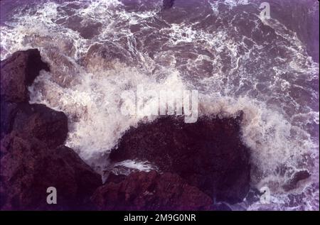 Attrition. L'attrition se produit lorsque des matériaux tels que des roches et des pierres transportées par des vagues frappent et se cognent les uns contre les autres les usant. Comme ces matériaux sont usés le sable et les galets de plage arrondis sont formés. Falaises. Les falaises de mer sont l'un des exemples les plus clairs de l'érosion de la mer que nous pouvons voir.Une vague de plongée se brise avec plus d'énergie qu'une vague de déversement beaucoup plus grande. L'onde peut piéger et comprimer l'air sous la lèvre, ce qui crée le son de « choc » associé aux vagues. Avec les grandes vagues, cet accident peut être ressenti par les personnes en bord de mer sur terre. Banque D'Images