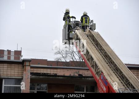 Brovary, Ukraine, 18 janvier 2023. - Deux sauveteurs utilisent une échelle aérienne sur la scène de l'accident mortel d'hélicoptère dans un jardin d'enfants à Brovary, dans la région de Kiev, dans le nord de l'Ukraine. Comme on l'a signalé, 16 personnes, dont trois enfants, sont mortes et 30 personnes ont été admises à l'hôpital. Les neuf personnes à bord - six membres du groupe opérationnel du ministère des Affaires intérieures, y compris le ministre Denys Monastyrskyy, et trois membres d'équipage du service d'urgence de l'État - sont parmi les morts.Credit:Ukrinform/Alamy Live News Banque D'Images