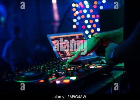 DJ joue de la musique sur un mélangeur professionnel de contrôleur d'équipement de musique sur présentation dans une boîte de nuit Banque D'Images