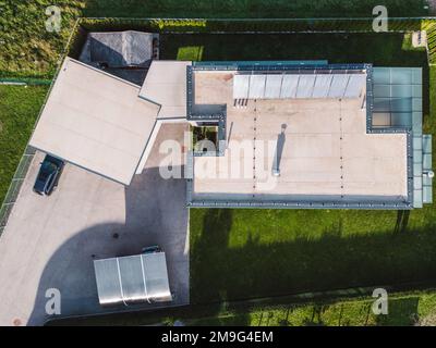 Directement au-dessus d'une maison moderne dans la banlieue avec toit plat et panneaux solaires dessus Banque D'Images