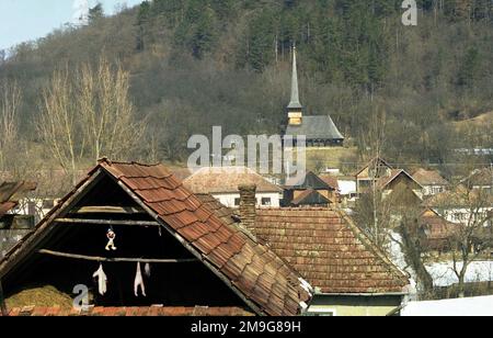 Comté de Salaj, Roumanie, environ 1999. Vue sur le village de Voivodeni, avec l'église orthodoxe en bois (1822) vue sur la colline. Banque D'Images