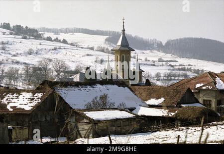 Comté de Salaj, Roumanie, environ 1999. Vue sur le village de Voivodeni, avec la nouvelle église orthodoxe (1962) vue derrière la ferme. Banque D'Images