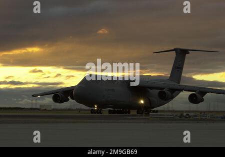 Une galaxie C-5B de la Réserve de l'Armée de l'Air passe devant la station-service à la lumière du soir à l'aérodrome fédéral de Moffett, Mountain View, Californie. Capable de contenir 51 150 gallons de carburant, un C-5 avec une charge de 270 000 livres peut voler 2 150 milles marins, décharger, et voler vers une deuxième base à 500 milles marins de distance. Base: Moffett Federal Air Field État: Californie (CA) pays: États-Unis d'Amérique (USA) scène Major Command montré: 129th Rescue Wing Banque D'Images