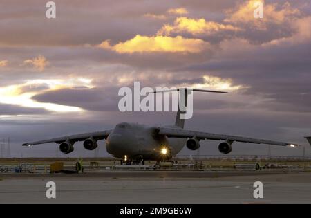 Une galaxie C-5B de la Réserve de l'Armée de l'Air passe devant la station-service à la lumière du soir à l'aérodrome fédéral de Moffett, Mountain View, Californie. Capable de contenir 51 150 gallons de carburant, un C-5 avec une charge de 270 000 livres peut voler 2 150 milles marins, décharger, et voler vers une deuxième base à 500 milles marins de distance. Base: Moffett Federal Air Field État: Californie (CA) pays: États-Unis d'Amérique (USA) scène Major Command montré: 129th Rescue Wing Banque D'Images