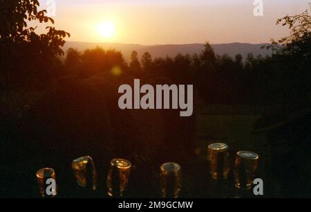 Comté de Salaj, Roumanie, environ 1998. Videz les pots de verre sur une clôture dans la lumière du coucher du soleil. Banque D'Images