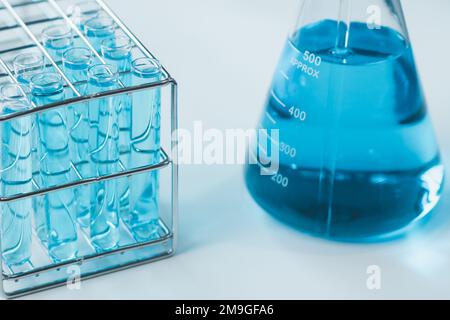 Tubes à essai et erlenmeyer remplis d'échantillons de produits chimiques bleus en laboratoire de chimie. Verrerie dans la recherche médicale. Laboratoire scientifique pour B Banque D'Images