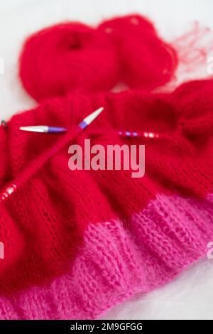 Pull en maille de mohair rouge et rose vif avec coutures, y compris couture et côtes, tricoté sur aiguilles circulaires. Banque D'Images