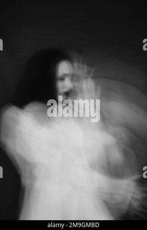 Portrait d'une fille avec des troubles mentaux. Noir et blanc de style vintage avec flou et ajout de grain Banque D'Images