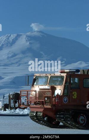 Le panache du mont Erebus, un volcan actif, offre un décor pour un véhicule d'urgence notwell 240 en premier lieu, stationné sur le plateau de glace Ross près de la station McMurdo en Antarctique, pendant l'opération DEEP FREEZE 2001. Objet opération/série: DEEP FREEZE 2001 base: Station McMurdo pays: Antarctique (ATA) Banque D'Images