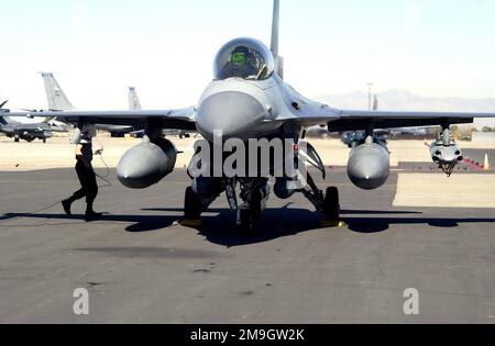 Un AVIATEUR du 421st Escadron de chasseurs de la base aérienne de Hill se prépare à retirer les cales d'un faucon de combat F-16D. Le F-16D, avec deux réservoirs de 600 gallons et un porte-bombe d'entraînement SSU-20, a été stationné sur la ligne aérienne de nuit de la Garde nationale de l'Utah Air et part maintenant pour une mission d'entraînement. La rampe ANG de l'Utah accueille régulièrement des avions temporaires. Base: Salt Lake City État: Utah (UT) pays: Etats-Unis d'Amérique (USA) scène Major Command montré: ANG Banque D'Images