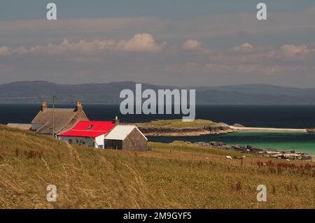 En regardant devant une maison au toit rouge jusqu'à White Strand de la plage de Monk, Iona et à Ulva et Mull au loin, Écosse Royaume-Uni Banque D'Images