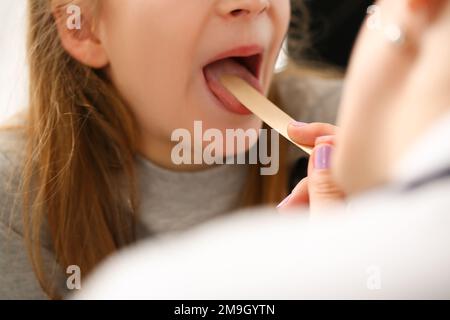 L'otorhinolaryngologiste examine une fillette atteinte d'un mal de gorge Banque D'Images