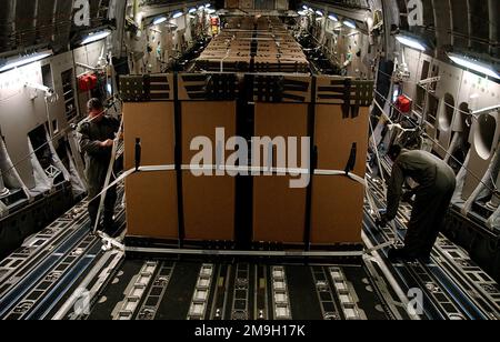 DF-SD-03-17239. [Complet] Légende de la scène: LES charmeurs de LA US Air Force C-17A Globemaster III inspectent le système de livraison aérienne à trois murs (TRIADES) chargé de rations humanitaires quotidiennes (HDR) en route vers la zone de chute. Les forces aériennes C-17 ont fourni des rations humanitaires quotidiennes (RDH) à l'appui de l'opération ENDURING FREEDOM d'Allemagne aux réfugiés afghans qui se sont massés à l'intérieur des frontières de l'Afghanistan. Le C-17 transportait plus de 35 000 HDR emballés dans 84 TRIADE boîtes. Chaque boîte mesure 80 pouces de hauteur et 48 pouces de carré, contenant 420 HDR. Les HDR ont été livrés dans un premier de son genre, l'air de haute altitude Banque D'Images