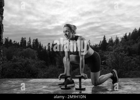 Femme s'exerçant à l'extérieur avec des haltères, Bainbridge Island, Washington, États-Unis Banque D'Images
