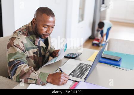 Heureux père afro-américain portant un uniforme militaire et son fils travaillant et jouant Banque D'Images