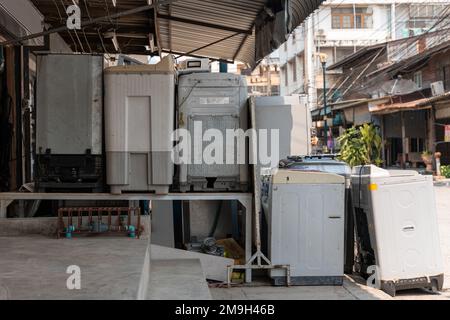 Un ancien lave-linge abandonné se trouve devant un atelier de réparation d'appareils Banque D'Images