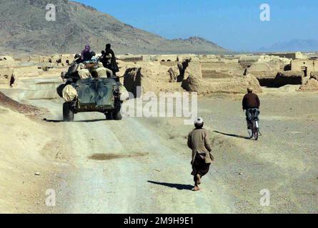 Un garçon afghan court derrière un VBL-25 (véhicule blindé léger) affecté aux Marines de la Compagnie Alpha, deuxième Bataillon de reconnaissance blindé léger, 26th unité expéditionnaire maritime (capacités d'opérations spéciales). Les Marines effectuent une patrouille montée à travers un village près de l’aéroport international de Kandahar, à Kandahar, en Afghanistan, au cours DE L’OPÉRATION ENDURING FREEDOM. Objet opération/série: BASE DE LIBERTÉ DURABLE: Aéroport international de Kandahar pays: Afghanistan (AFG) scène Major Command montré: 26 MEU Banque D'Images