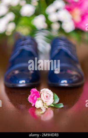 Petit bouquet de fleurs près des vêtements de mariage d'homme. Banque D'Images