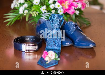 Petit bouquet de fleurs près des vêtements de mariage d'homme. Banque D'Images