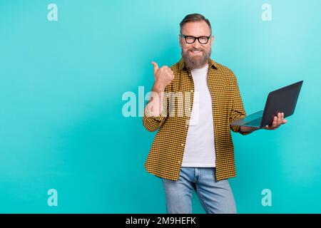 Photo d'expert programmeur âge moyen homme ensemble élégant montrer mockup doigt tenir netbook recommander site Web isolé sur fond bleu-vert couleur Banque D'Images
