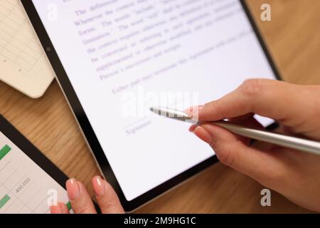 Une femme d'affaires appose sa signature sur son contrat sur sa tablette. Banque D'Images