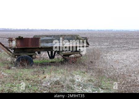 Ancienne remorque de tracteur cassée. Matériel agricole abandonné. Banque D'Images