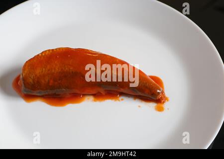 Sardines dans une sauce tomate sur une assiette blanche. Sardines en conserve. Banque D'Images