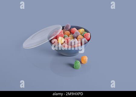 Jelly bean colorée dans un bol isolé sur fond coloré Banque D'Images