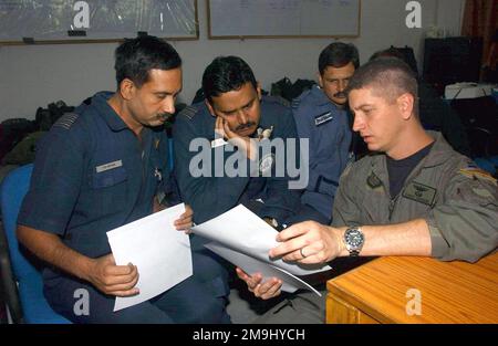 LE capitaine (CPT) de la Force AÉRIENNE DES ÉTATS-UNIS (USAF) David Hanson (à droite), un pilote affecté à l'escadron DES opérations spéciales (SOS) DU 1st e Escadron des opérations spéciales (SOG) du 353rd e Groupe des opérations spéciales (SOG), discute des procédures de la mission avec le commandant de la Force aérienne indienne (FIA), Partha Sarathi Bose (à gauche); Les dirigeants de l'escadron IAF, NAND Kumar Nair (au centre) et IAF Sangeet Bhatnagan, en préparation d'une mission d'entraînement de chute d'air à la station de la Force aérienne Agra, en Inde. Les membres de la SOG de 353rd sont déployés ici pour trois semaines de formation conjointe en échange avec les Forces armées indiennes. Base: Station de la Force aérienne Agra pays: Inde (IND) Banque D'Images