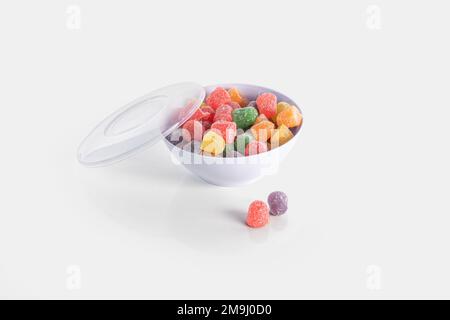 Jelly bean colorée dans un bol isolé sur fond coloré Banque D'Images