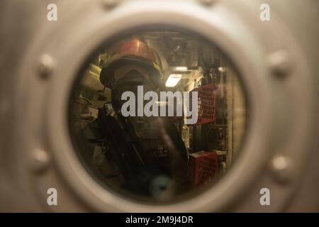 MER DES PHILIPPINES (19 MAI 2022) Un marin se prépare à ouvrir une trappe lors d'un exercice de contrôle des dégâts à bord du destroyer guidé de classe Arleigh Burke USS Dewey (DDG 105). Dewey est affecté au commandant de la Force opérationnelle 71/Escadrier Squadron (DESRON) 15, la plus grande force de surface déployée à l’avant de la Marine et la principale force de surface de la flotte américaine 7th. Banque D'Images