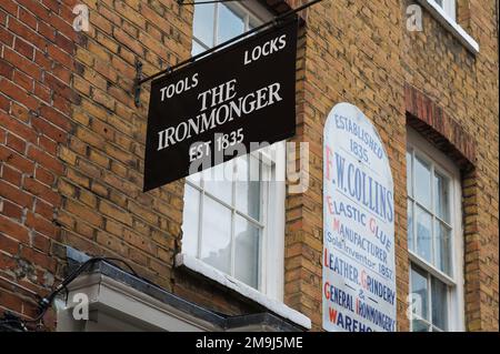 The Ironmonger, panneaux sur le mur au-dessus des magasins dans Monmouth Street, Seven Dials, Covent Garden, Londres, Angleterre, ROYAUME-UNI Banque D'Images