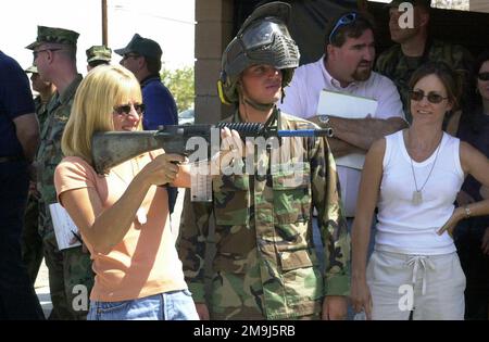 020808-F-0981H-112. [Complete] Scene Caption: Une femme non identifiée membre des médias civils se prépare à tirer une ronde de simunition d'un corps des Marines des États-Unis (USMC) M4A1Carbine en tant que caporal de lance de l'USMC Albert Petronzio, 3 Bataillon, 7 Marines, stand by pour aider, Lors d'une manifestation de combat de guerre urbaine organisée à l'aéroport de logistique de Californie du Sud (SCLA), (anciennement la base aérienne de George), dans le cadre du processus d'expérimentation de service conjoint appelé Millennium Challenge 2002 (MC02). Les munitions de simulation sont des munitions simulées qui enflamme un projectile de peinture et sont utilisées pour l'entraînement. Le rapport i Banque D'Images