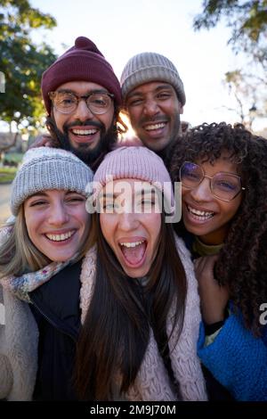 Groupe multiethnique de personnes prenant le selfie en plein air regardant l'appareil photo joyeusement. Banque D'Images