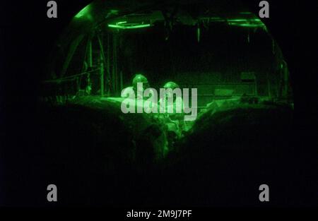 Photographie légère, vue de la lentille fisheye, à bord d'un avion C-130E Hercules de la US Air Force (USAF) affecté au 41st Airlift Squadron, 43rd Operations Group, alors que les chargés de charge effectuent une liste de contrôle du fret, avant leur premier système de livraison de conteneurs de combat (CDS) à l'aide de lunettes de vision nocturne, tout en soutenant l'opération ENDURING FREEDOM. Sujet opération/série: LIBERTÉ DURABLE pays: Inconnu Banque D'Images