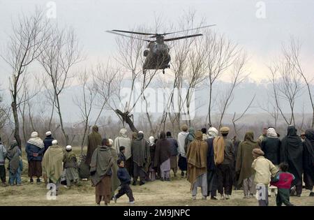 Les citoyens afghans attendent comme hélicoptère CH-47 Chinook des terres avec des fournitures médicales et des traitements pour le village d'Aroki, à l'appui de l'opération ENDURING FREEDOM. Sujet opération/série: LIBERTÉ DURABLE pays: Afghanistan (AFG) Banque D'Images