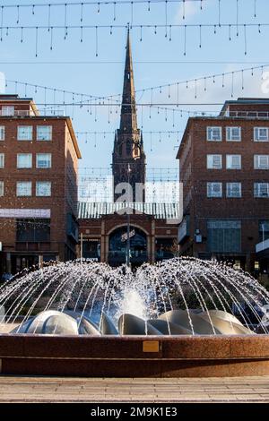 La fontaine de la pièce maîtresse de Smithford Way dans le centre de Coventry entre les quartiers supérieur et inférieur. L'ensemble de la zone a été rénové pour la ville de Culture 2021. La vue de la fontaine donne sur la partie supérieure du quartier vers la flèche de l'église de la Sainte Trinité au loin. Banque D'Images