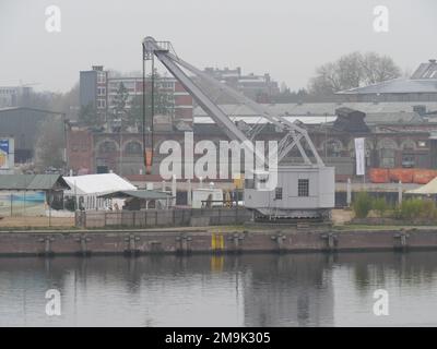 Ancien historique sur des rails exécutant une grue de chargement jaune pour cargo pour la navigation fluviale à Luebeck. Banque D'Images