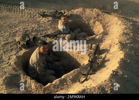 Avec leurs fusils d'assaut Colt 5,56mm M16A2 à proximité, le caporal Hoxworth (CPL) du corps maritime américain (USMC) et le hall CPL, s'assoient dans leurs trous de combat pendant l'opération ENDURING FREEDOM. Objet opération/série: LIBERTÉ DURABLE pays: Koweït (KWT) Banque D'Images