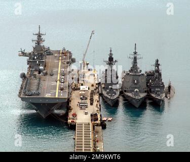 Angle élevé, arc sur la vue, montrant les navires de la Marine américaine (USN) et de la Force d'autodéfense maritime japonaise (JMSDF), amarrés à la jetée et amarrés côte à côte, à l'installation portuaire de White Beach, située à Okinawa, au Japon. De gauche à droite sont photographiés la CLASSE USN WASP: Navire amphibie USS ESSEX (LHD 2), la classe JMSDF HATAKAZE: Destroyer, SHIMAKAZE (DDG 172), la classe JMSDF KONGOU: Destroyer, SUSOUKOU (DDG 175), la classe JMSDF ASAGIRI (DMASHIIO 155), la CLASSE JUSHIRD, la classe MYHIRSYI, la classe MAM (584), la classe MYHIRD, la classe JUSHISAM, la classe MAM (MAIRSYI), la classe État: Okinawa pays: Japon (JPN) Banque D'Images